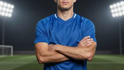 A 25-year-old American defender in a solid blue jersey, standing confidently with arms crossed