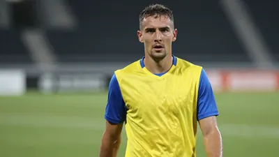 Mid-30s Lillestrøm forward, athletic build, waist-up, intense gaze, sweat-glazed skin, wearing a plain yellow jersey with...