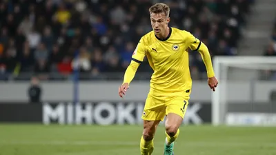 Photorealistic 85mm f/1.4 shot of a tall, athletic Lillestrøm SK midfielder in yellow kit, age 25-30, sprinting with the...